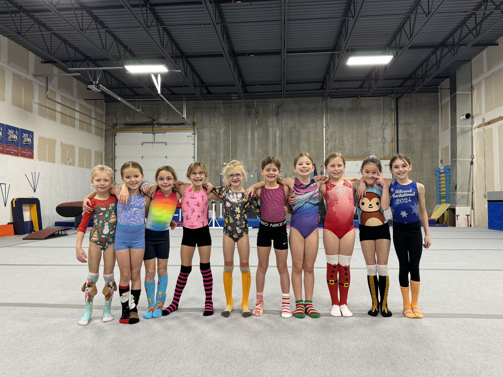 Gymnasts in fun socks lined up arm in arm at Lake Point
