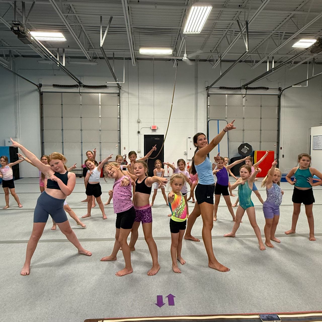 Lake Point gymnasts and coach striking a pose together
